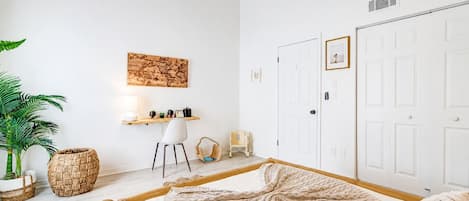 Une chambre à coucher comprenant un lit, un bureau, une chaise, une armoire et un ventilateur de plafond.