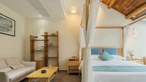 A bedroom with a bed, a nightstand, a wooden shelf unit, a sofa, and a table. - Anji Double Fish Hall Hot Spring Resort B&B (Longwangshan Canyon Drift Shop) (Anji)