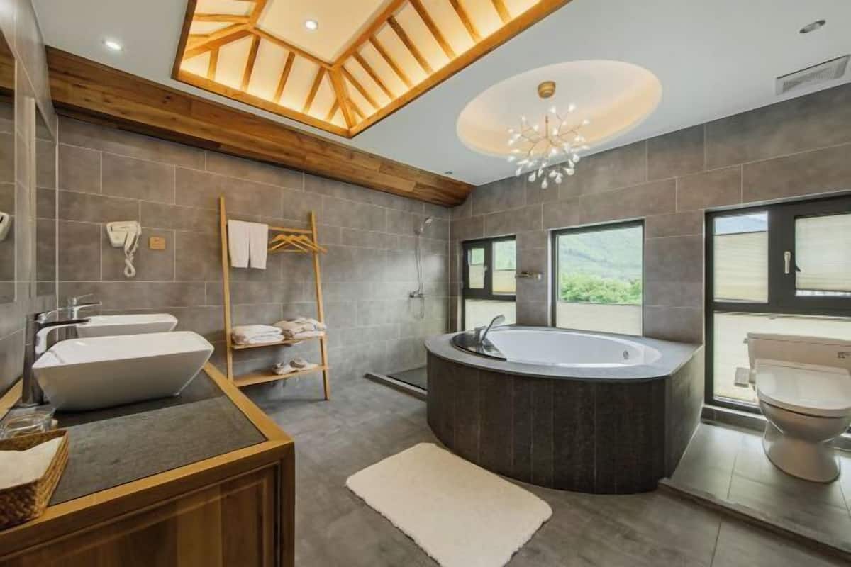 A modern bathroom with a freestanding bathtub, a double sink vanity, and a shower area.