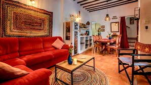 A living room with a red sofa, a coffee table, and a patterned rug.