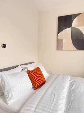 A hotel room with a bed, a wall-mounted artwork, and a power outlet. - Spacious 4BR Home | 3 Parking | Offers Weekly Stay (Reading)