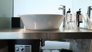 A modern bathroom with a white ceramic sink, a handheld showerhead, and a Safewell 25EK water heater. - Rucksack Inn Premium Melaka (Malacca City)