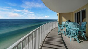 A balcony with turquoise chairs and tables overlooking a clear blue ocean. - NEW Emerald Isle 2107 "Manta Ray Villa" Pool, FREE Perks&Beach Service for 4! (Panama City Beach)