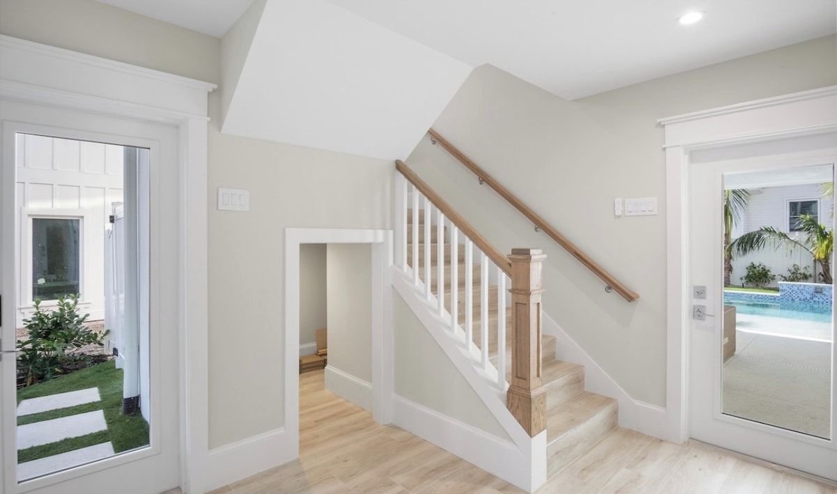 A staircase with white railings and wooden steps leading to a second floor.