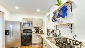 A modern kitchen with stainless steel appliances, a wooden countertop, and a built-in oven.