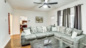 A living room with a sectional sofa, a coffee table, and a ceiling fan.