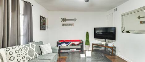 Una sala de estar con sofá, mesa de centro, televisor y ventilador de techo.