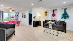 A modern living room with a sofa, coffee table, and artwork on the walls. - Heated Saltwater Pool < 2 Mi to Yacht Club Beach! (Cape Coral)