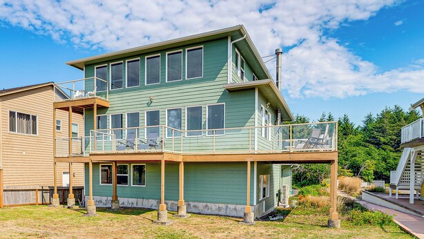 A two-story building with a balcony and a covered porch.