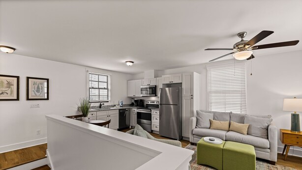 A modern kitchen with white cabinets, stainless steel appliances, and a ceiling fan. - Pet-friendly Renovated Apt Steps to Forsyth, Coffee Shops by Lucky Savannah (Savannah)