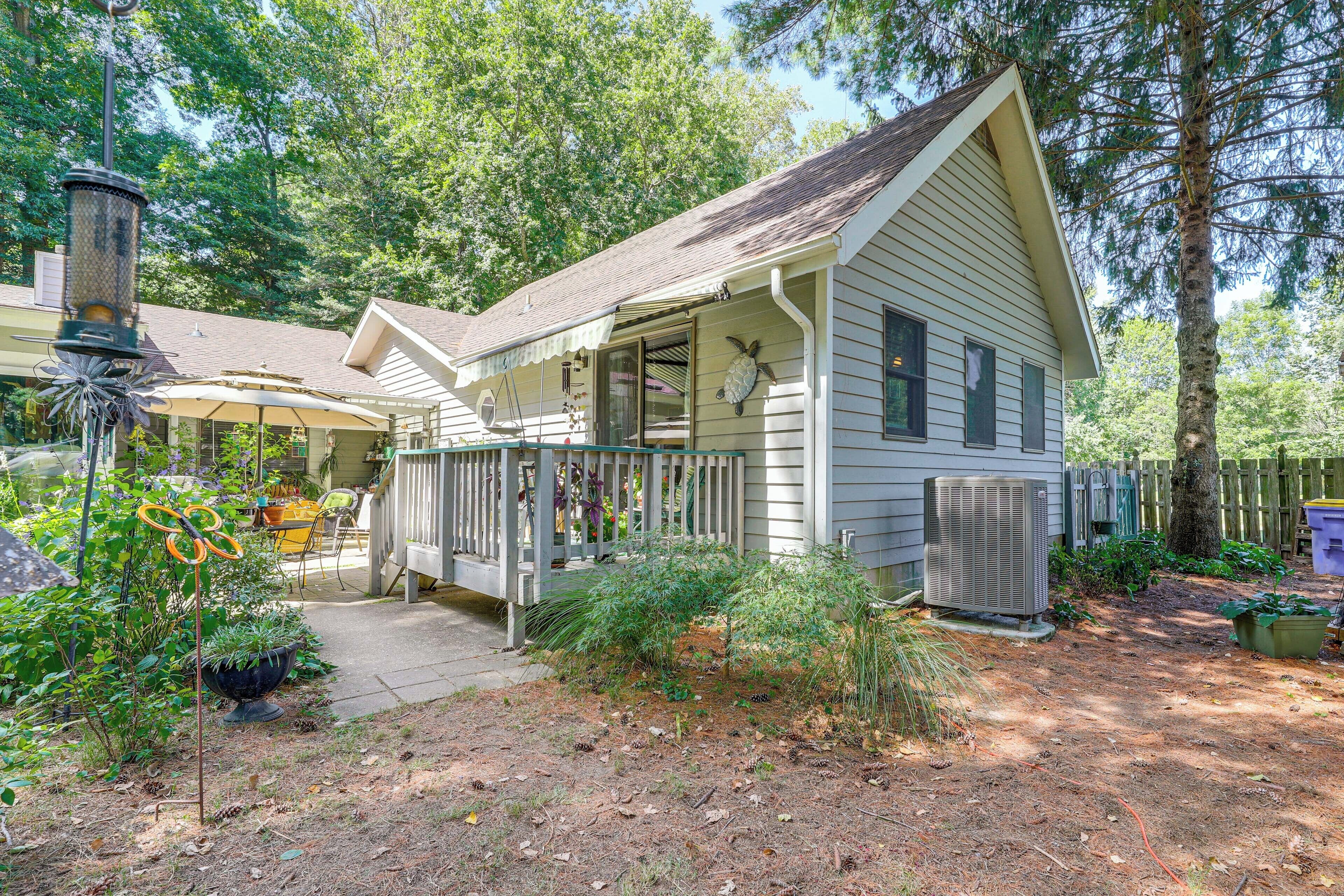 A single-story house with a porch, a covered patio, and a small garden area.