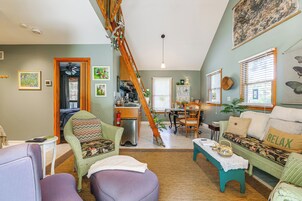 Una sala de estar acogedora con una escalera, un comedor y una cocina.