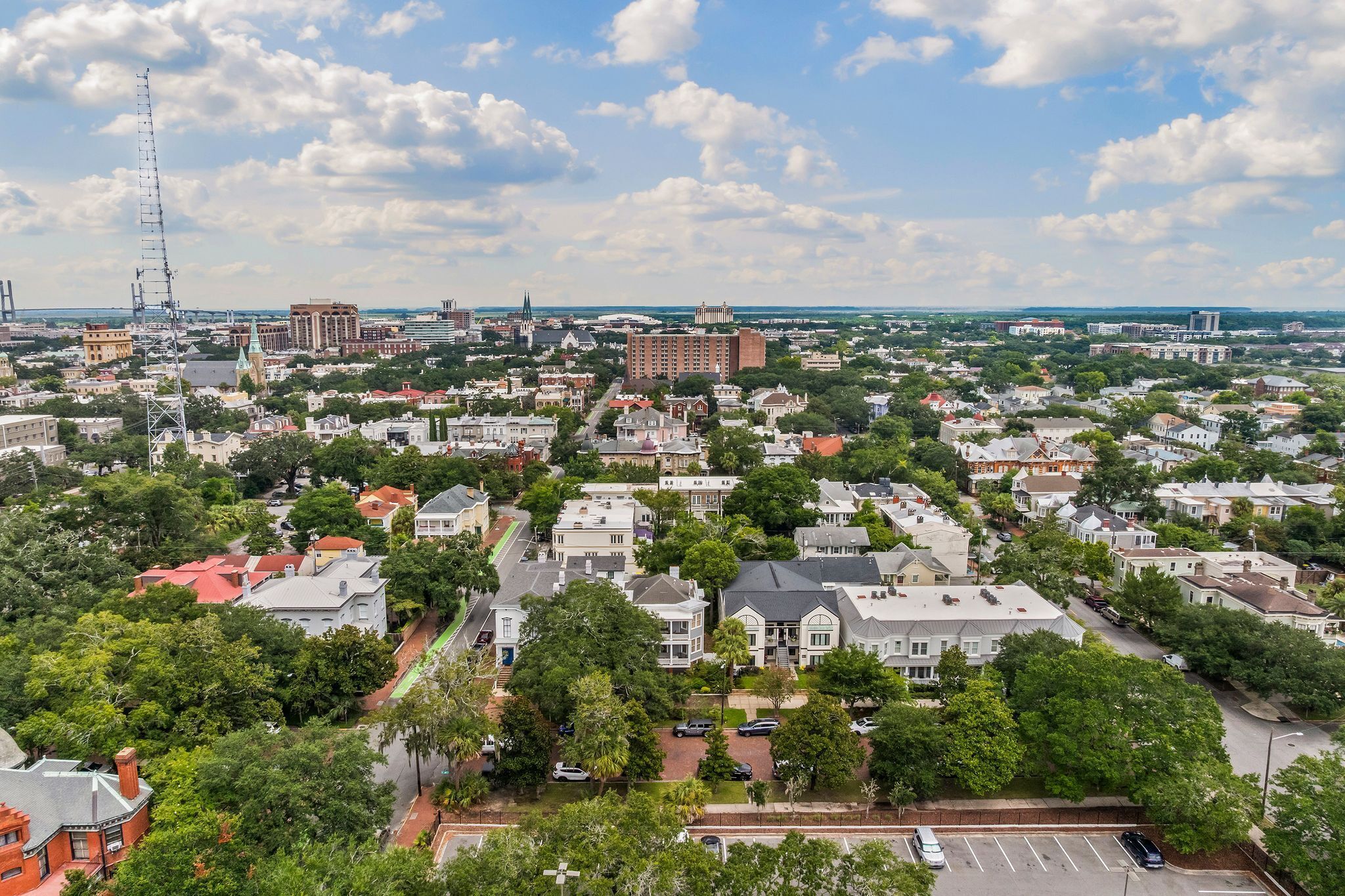 An aerial view of a city with residential areas, roads, and a prominent tower.
