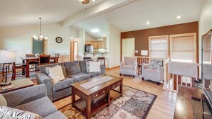 A spacious living room with a ceiling fan, a dining area with a table and chairs, and a kitchen in the background. - < 2 Mi to Granby Ranch: Home w/ Hot Tub & Decks! (Granby)