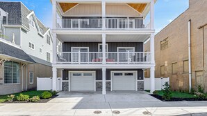 A two-story building with a balcony on the upper floor, a garage on the ground floor, and a brick exterior wall.