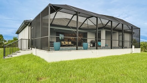 Ein modernes Haus mit einer großen, einsehbaren Veranda, einer Treppe und einem Poolbereich.