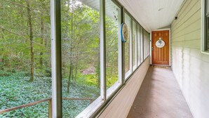 A covered hallway with large windows overlooking a forested area. - Creekside Family Home in Cleveland: Stay & Play! (Cleveland)