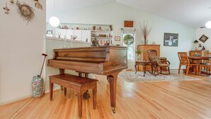 A spacious living room with a grand piano, wooden dining table, and chairs. - Carrboro Quaint! 2 Mi to Heart of Chapel Hill! (Carrboro)