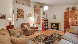 A cozy living room with a fireplace, a sofa set, a patterned rug, and a bookshelf. - Carrboro Quaint! 2 Mi to Heart of Chapel Hill! (Carrboro)