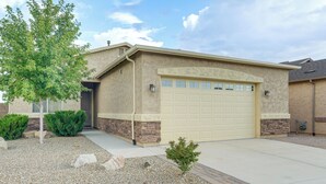 A single-story house with a beige garage door, a small front yard with gravel and a few shrubs, and a clear sky. - 7 Mi to Watson Lake: Prescott Valley Home w/ Patio (Prescott Valley)