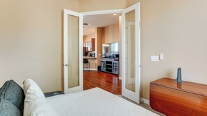 A bedroom with a bed, a wooden dresser, and a view into a kitchen area. - 7 Mi to Watson Lake: Prescott Valley Home w/ Patio (Prescott Valley)