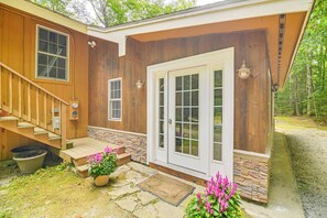 A wooden house with a front porch, stone steps, and a door with glass panels. - Walk to Water: Outdoor Gem w/ Bunkhouse in Madison (Madison)