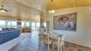 A spacious living area with a large sofa, dining table, and chairs, a ceiling fan, and a painting on the wall. - Walk to Lake: Scenic Southern Colorado Escape! (San Luis)