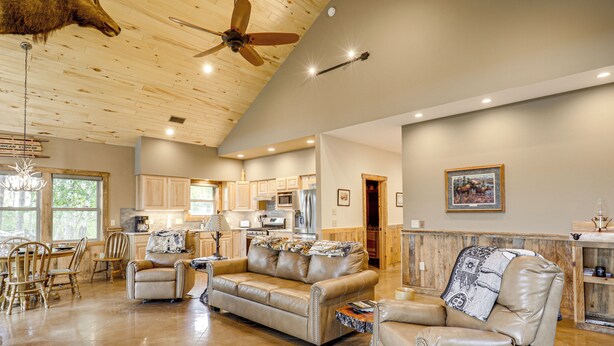 A spacious living room with a high ceiling, a ceiling fan, and a kitchen in the background. - 3 MI to Lake: Pet Friendly Wabeno Cabin! (Wabeno)