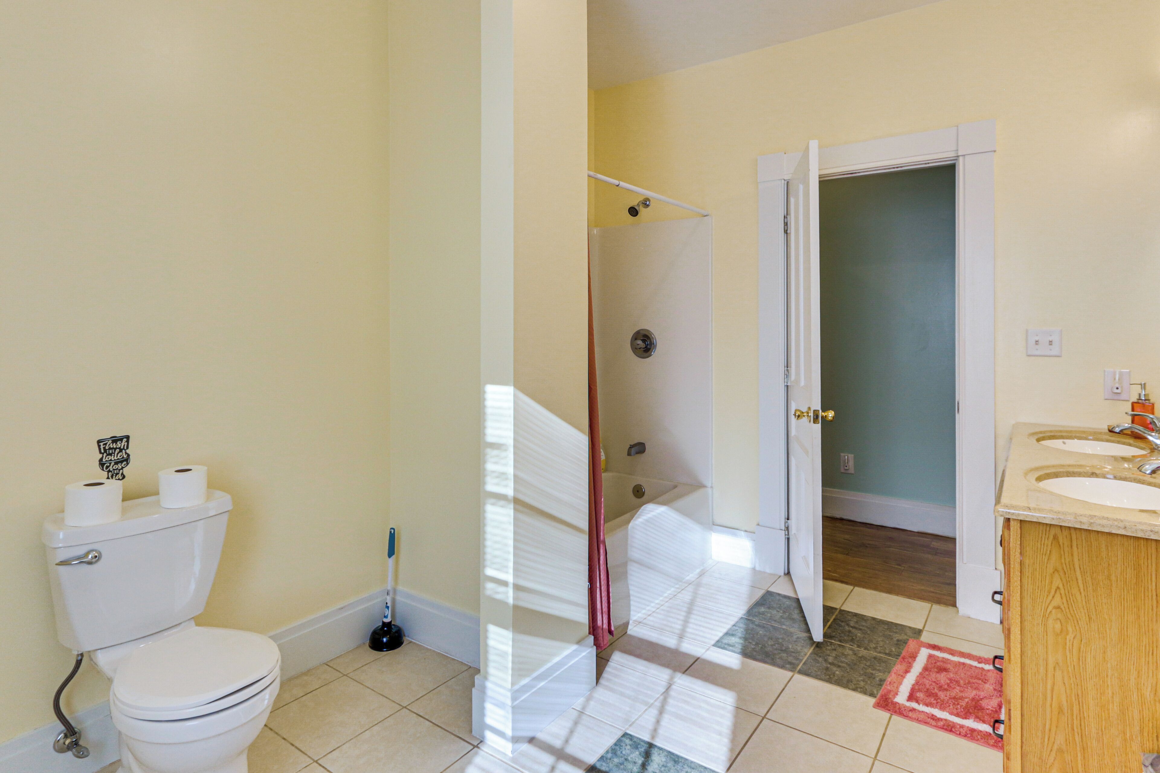 A bathroom with a toilet, shower, and sink.