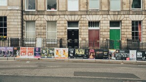 Une rangée de maisons de ville avec des portes numérotées, donnant sur une rue.