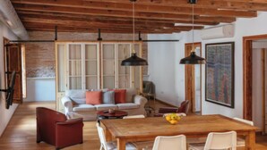 Un salón amplio con una mesa de comedor de madera, un sofá y un cuadro grande en la pared.