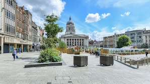 A public square with a prominent building featuring a dome, surrounded by historic buildings and a clear sky. - Market Street Apartment 3A Flat 1 (Nottingham)
