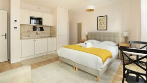 Ein modernes Schlafzimmer mit Bett, Nachttisch und kleinem Schreibtisch.