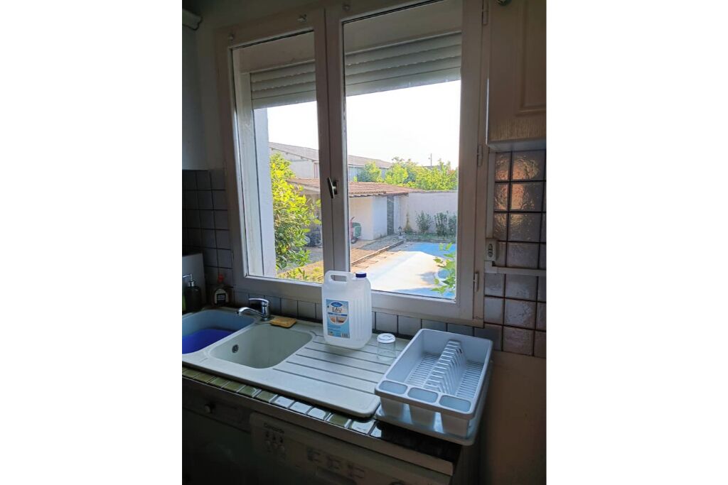 Una cocina con ventana, un lavamanos y una encimera.