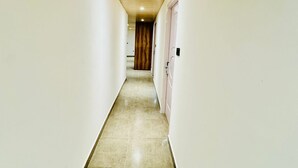 Un pasillo estrecho con paredes blancas y techo de madera.