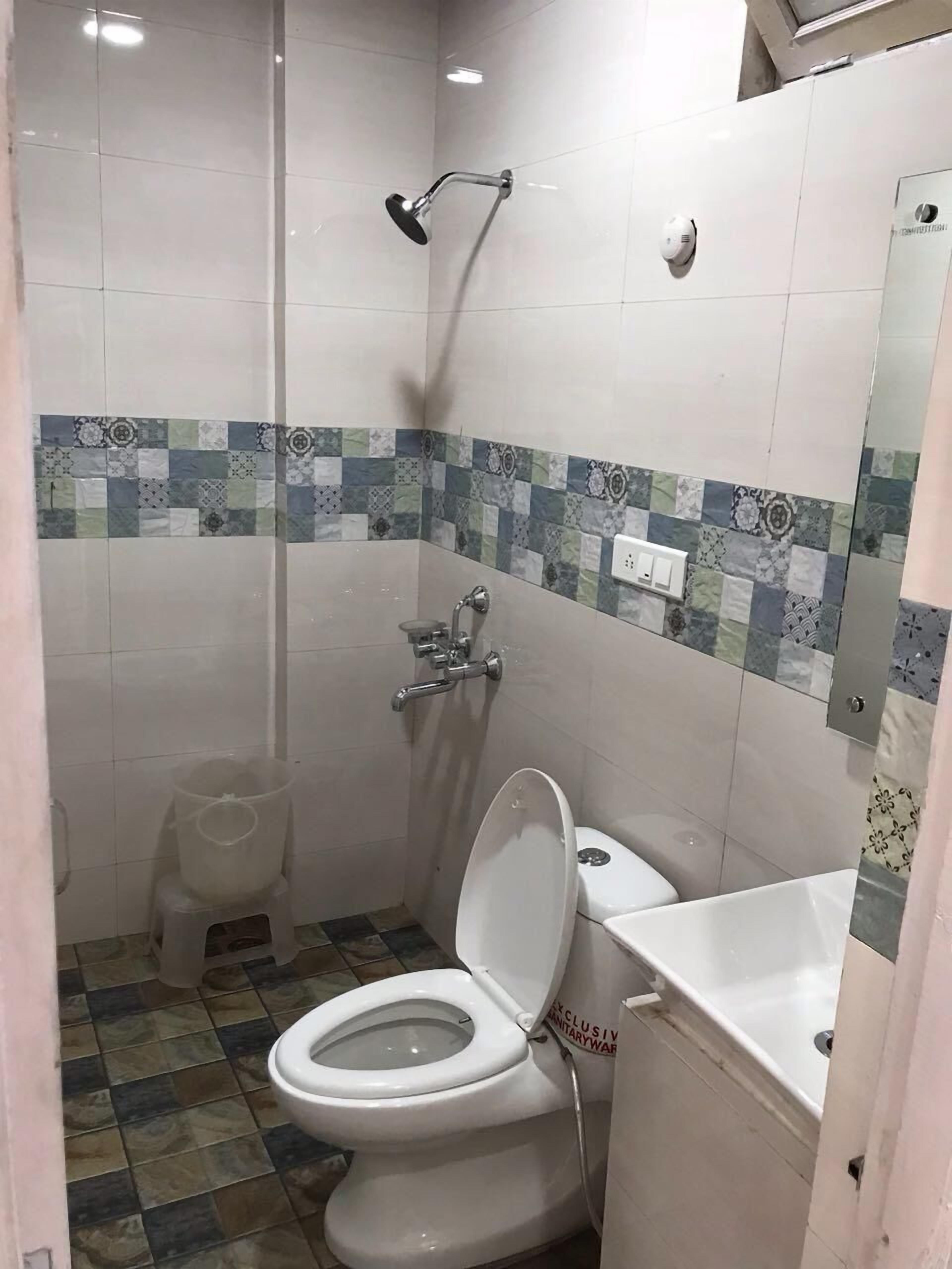 Un baño pequeño con inodoro, ducha y lavamanos.