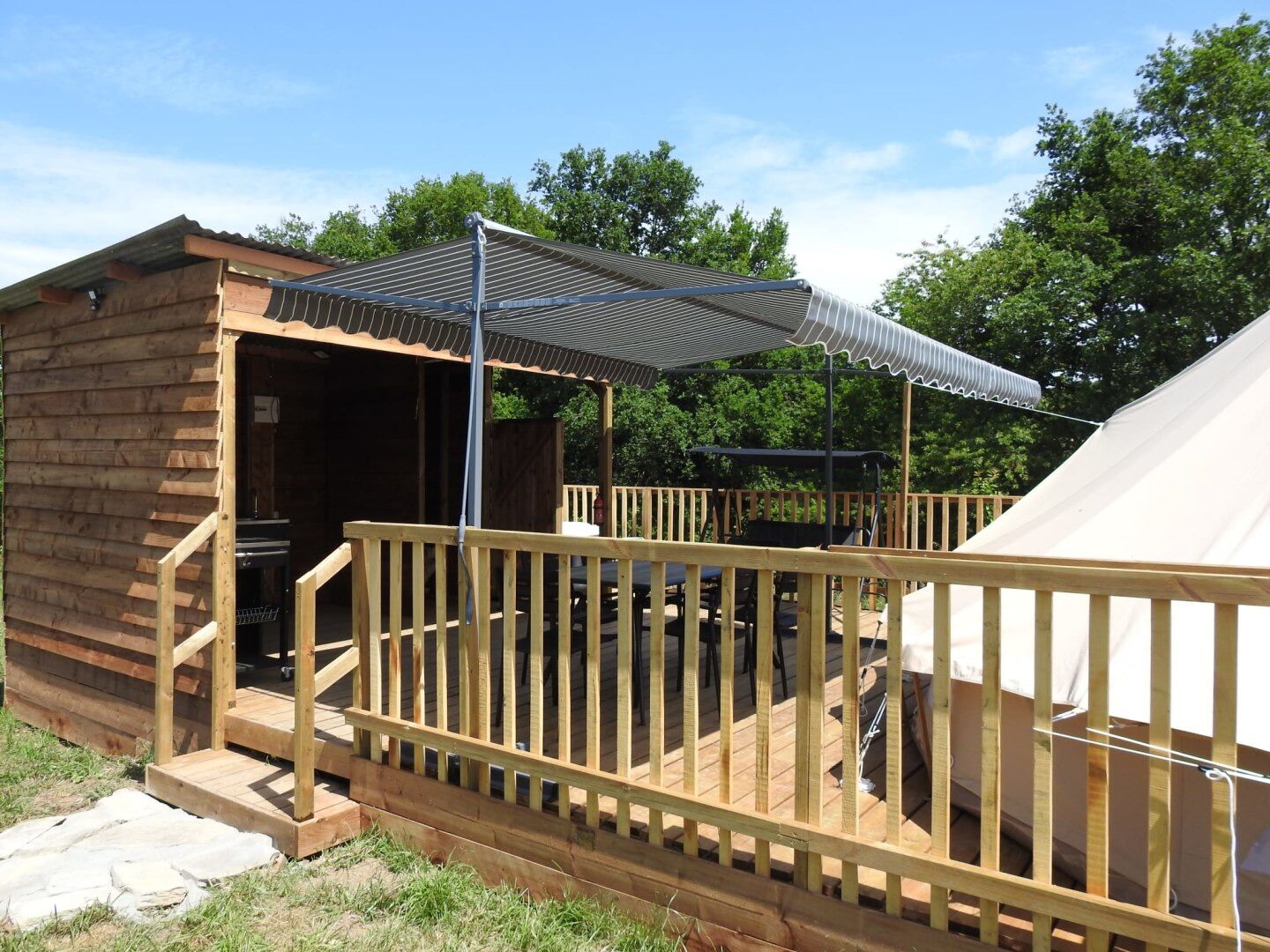Een houten chalet met terras en overdekte buitenruimte.