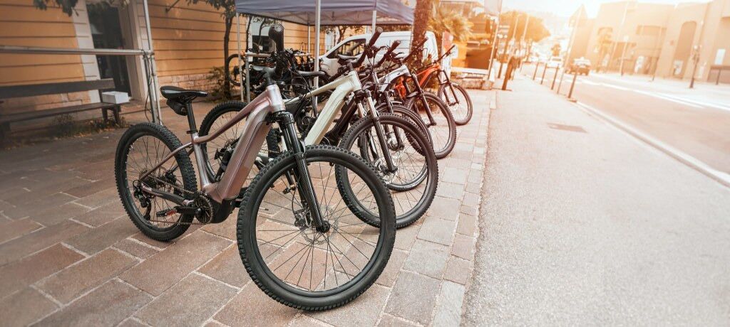 Fietsen staan geparkeerd op een verharde stoep naast een gebouw.