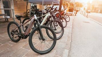 Fietsen staan geparkeerd op een verharde stoep naast een gebouw.