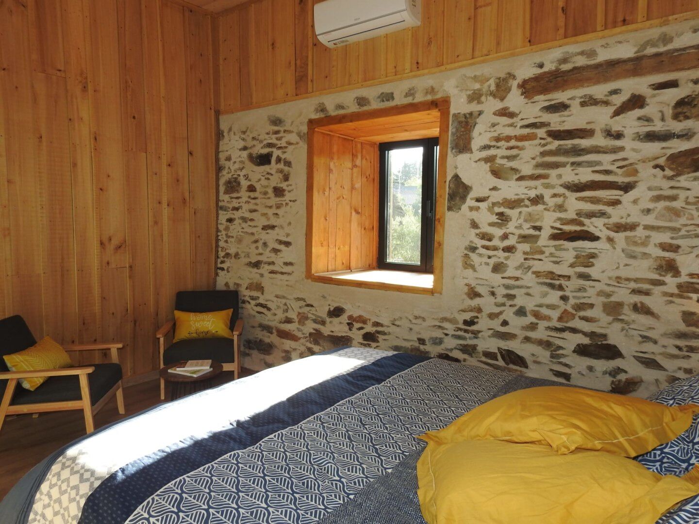 Una habitación con una cama, una silla y una ventana.