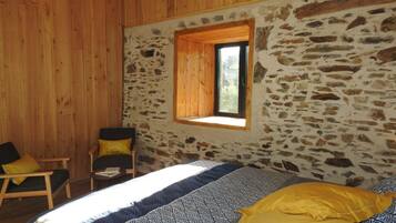 Una habitación con una cama, una silla y una ventana.