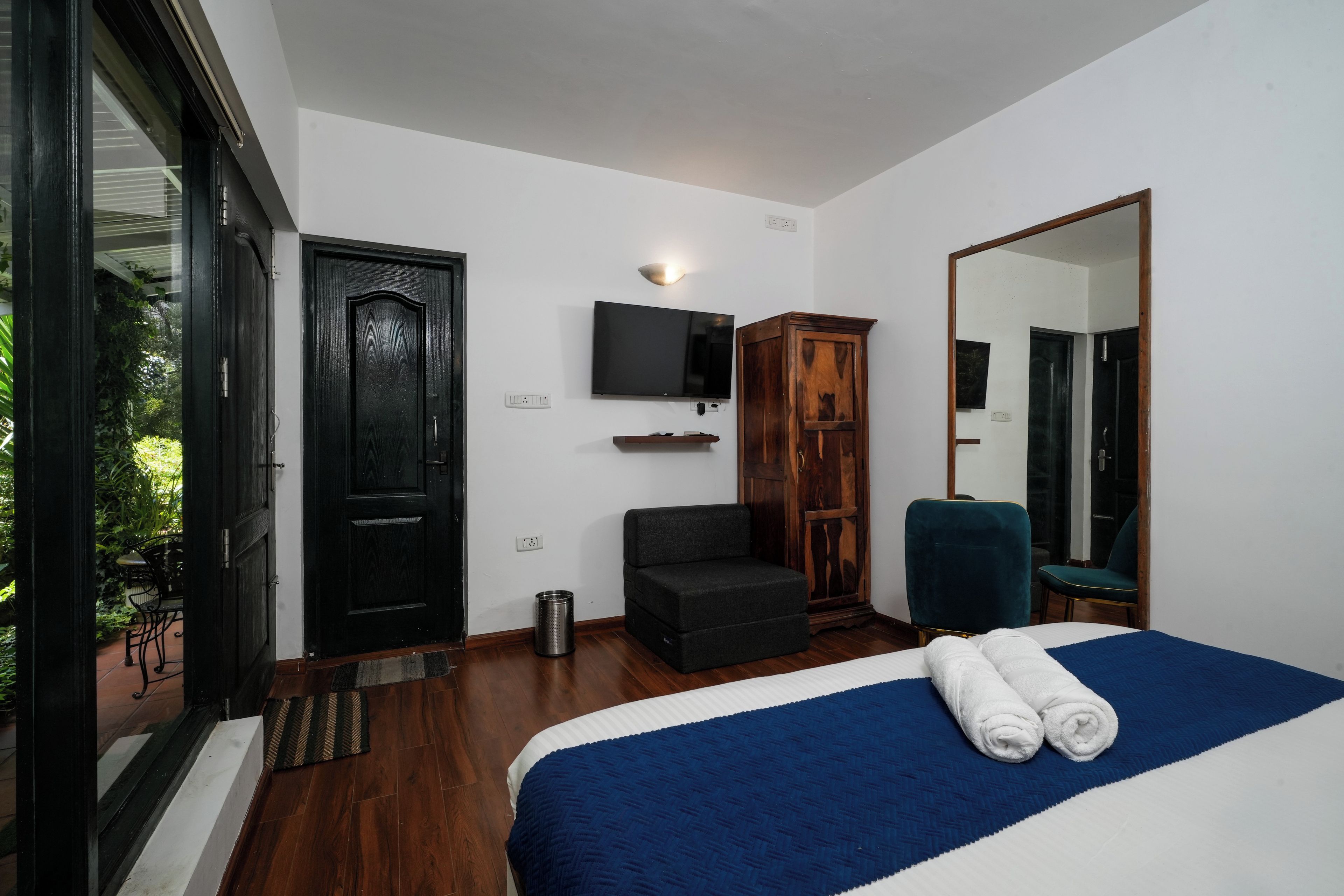 Ein Schlafzimmer mit einem großen Bett, einem Fernseher, einem Kleiderschrank und einem Spiegel.