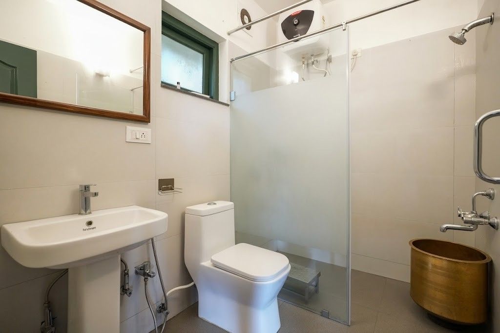 A bathroom with a white sink, toilet, and glass shower enclosure.