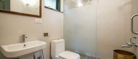 A bathroom with a white sink, toilet, and glass shower enclosure.