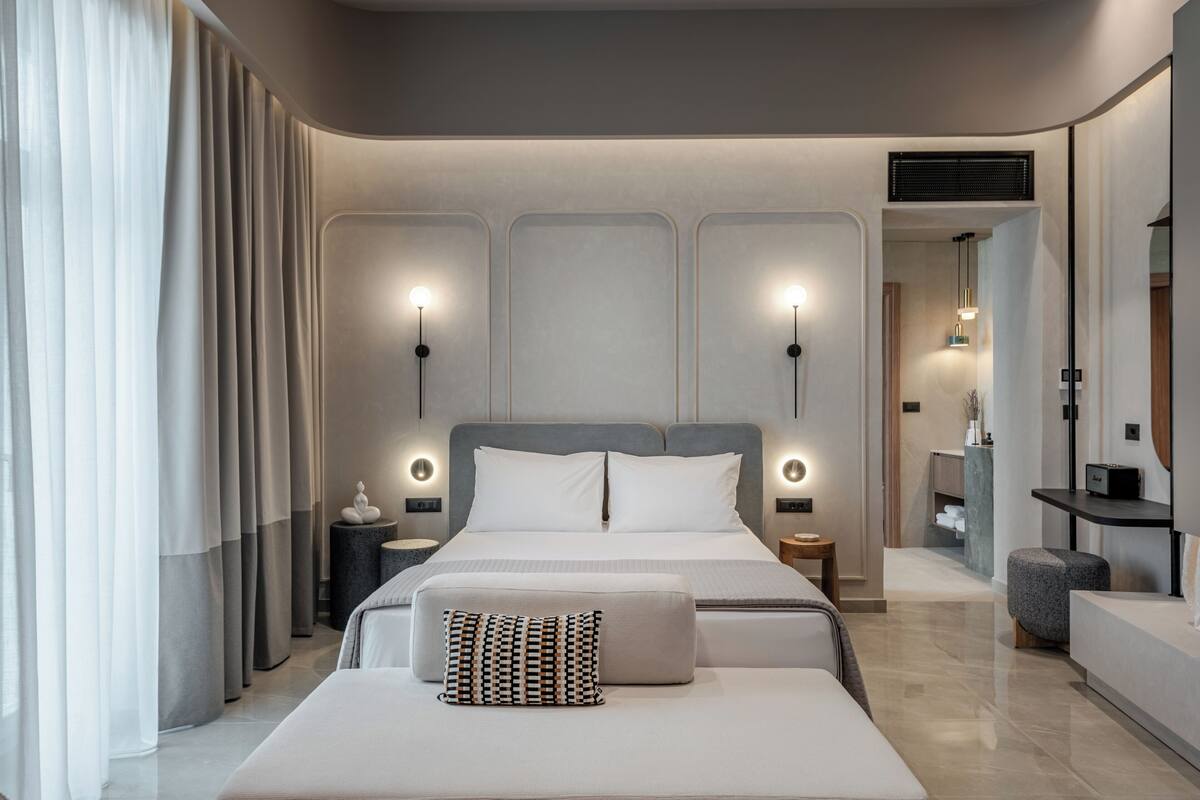 Um quarto moderno com uma cama grande, mesas de cabeceira e criado-mudo.