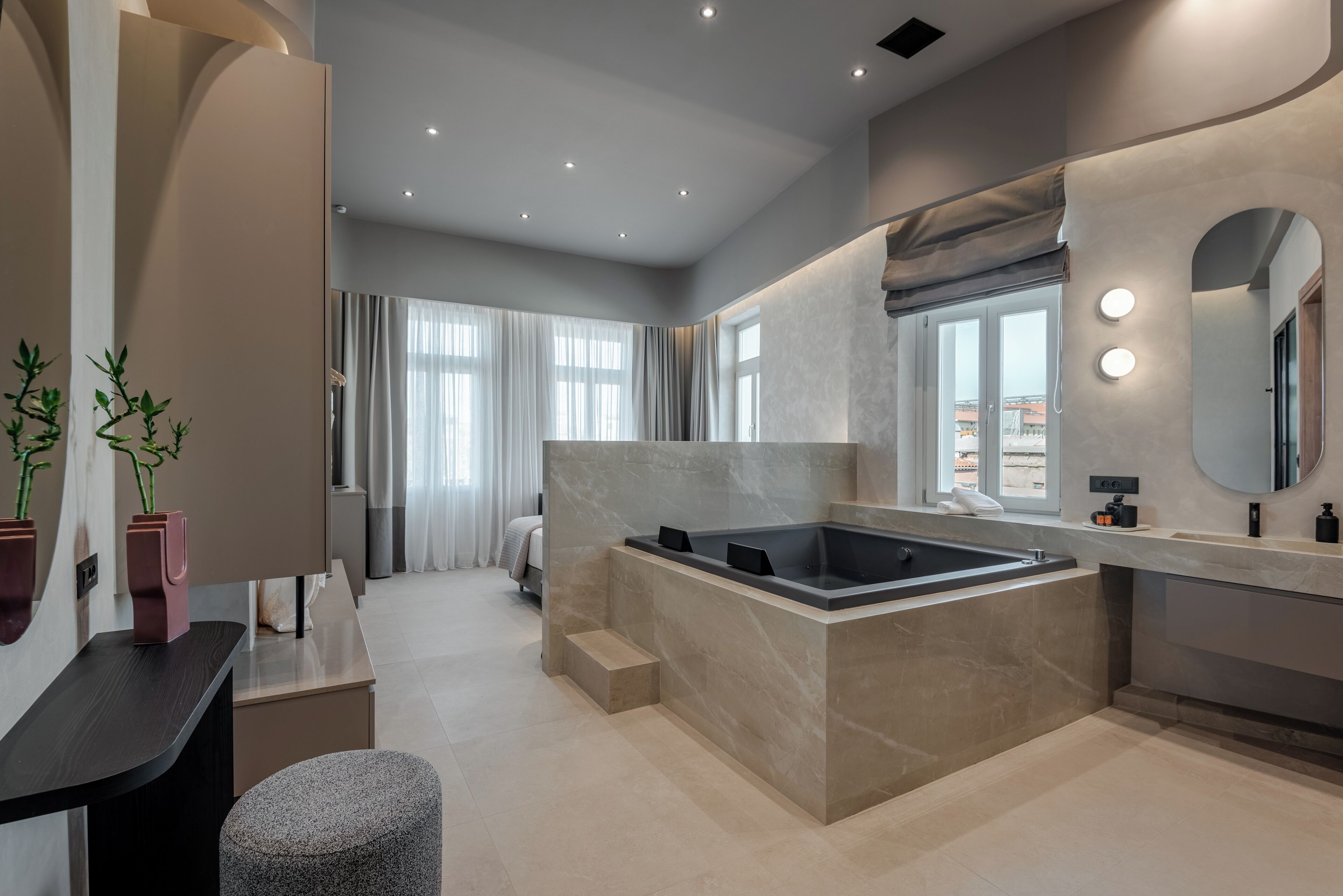 Un baño moderno con una bañera grande, un tocador con espejo y una zona de estar.