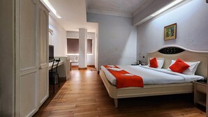 A bedroom with a bed, a desk, and a wardrobe.
