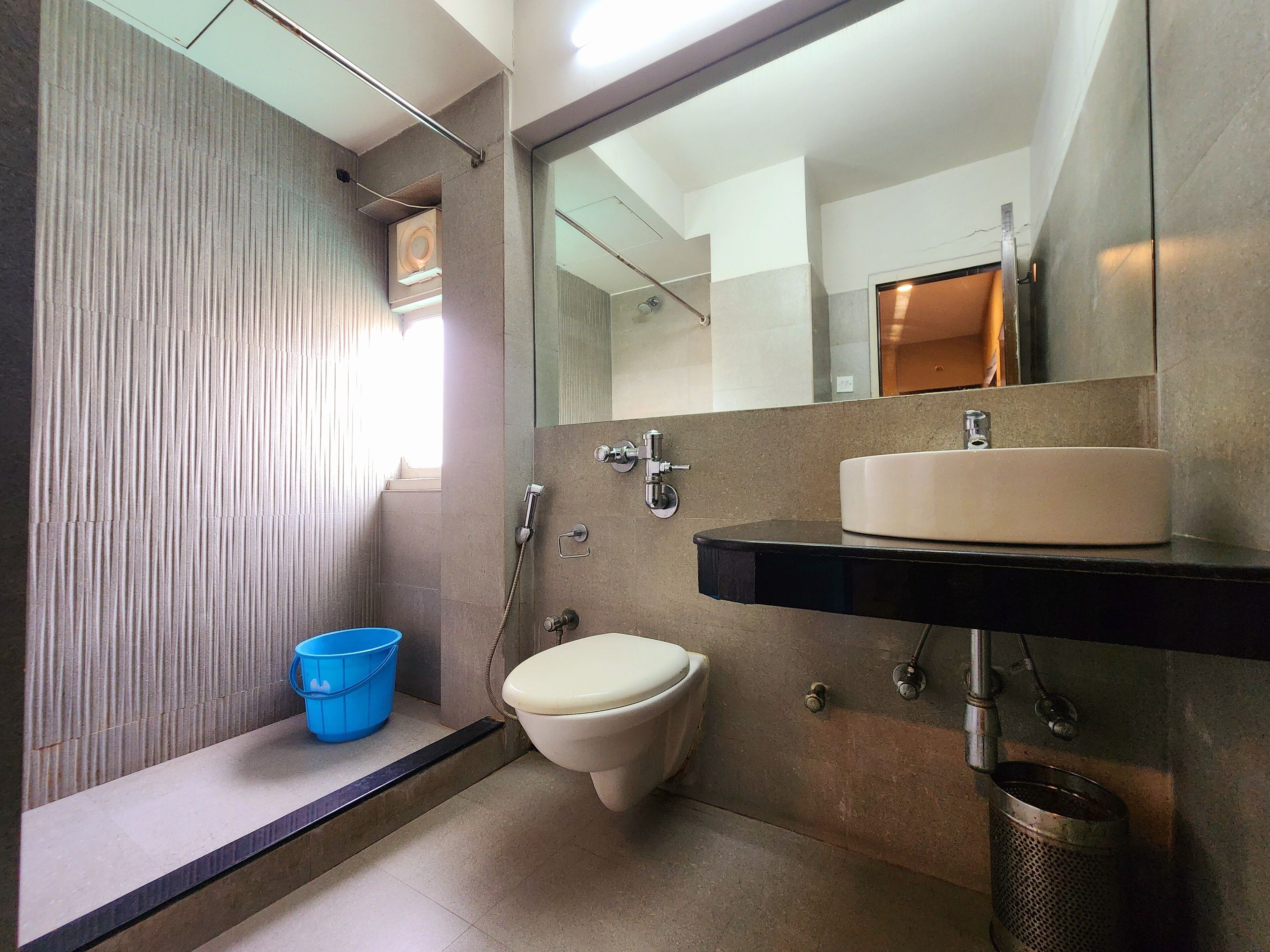 A modern bathroom with a toilet, sink, and shower.