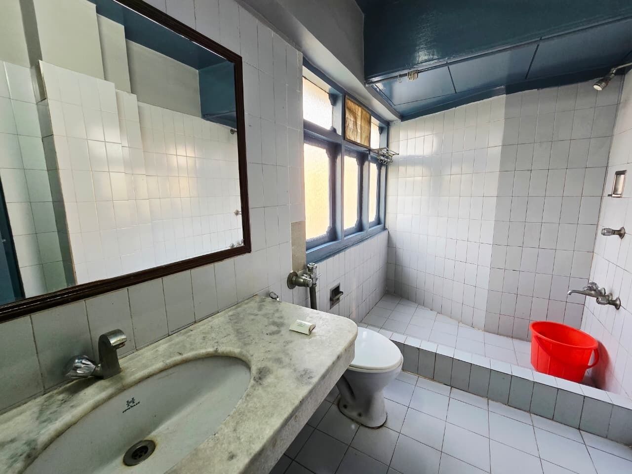 A bathroom with a marble sink, a toilet, and a bathtub.