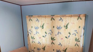A small, cozy room with a single bed, a wooden nightstand, and a curtain with a floral pattern. - Lake Okeechobee Hideout - On the water (Moore Haven)